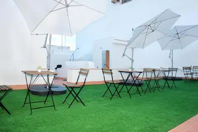 a group of tables and chairs with umbrellas at Plaza de España building in Cádiz