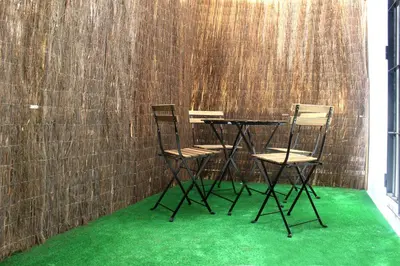 two chairs and a table with green carpet at Plaza de España building in Cádiz