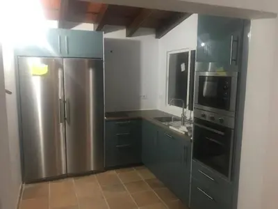 a kitchen with a table and a sink and a microwave at Casa independiente con piscina y pista deportiva privadas in El Puerto de Santa María