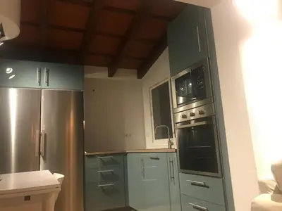 a kitchen with blue cabinets and stainless steel appliances at Casa independiente con piscina y pista deportiva privadas in El Puerto de Santa María