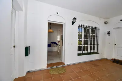 a hallway with white walls and a door with a gate at Apartamento La Barrosa - Chiclana - Urb. Pinar Atlántico in Chiclana de la Frontera