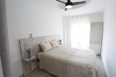 a white bedroom with a bed and a ceiling fan at Duque de Boliches in Arcos de la Frontera
