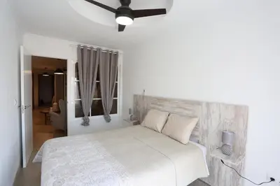a bedroom with a white bed with a wooden headboard at Duque de Boliches in Arcos de la Frontera