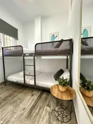 a room with two bunk beds and a table at GATU La Murallita en Puerto Sherry in El Puerto de Santa María