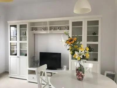 a white room with a table with a vase of flowers at Ático Cadiz al lado playa la Caleta in Cádiz