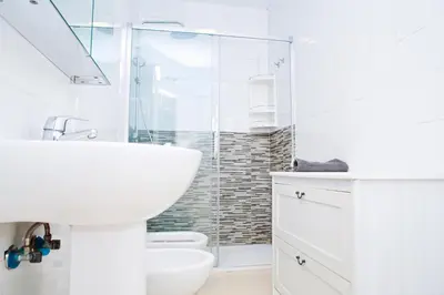a white bathroom with a sink and a shower at Ático Cadiz al lado playa la Caleta in Cádiz