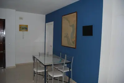 a dining room with a blue wall with a table and chairs at Torre de la Galeona in El Puerto de Santa María