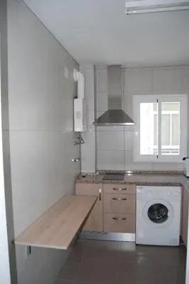 a kitchen with a wooden counter top and a washer at Torre de la Galeona in El Puerto de Santa María