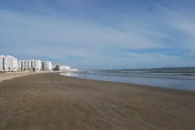 an empty beach with buildings in the background at Torre de la Galeona in El Puerto de Santa María