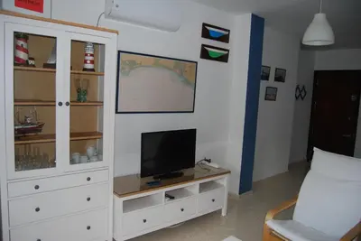 a living room with a tv and a white cabinet at Torre de la Galeona in El Puerto de Santa María