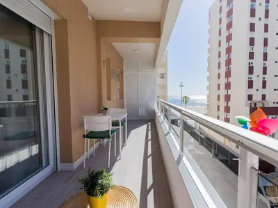 a balcony with a table and chairs on a building at Victoria - Apartamento Playa in Cádiz