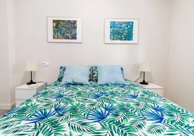 a bedroom with a bed with a blue and green blanket at Victoria - Apartamento Playa in Cádiz