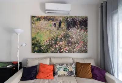 a living room with a couch with a painting on the wall at Victoria - Apartamento Playa in Cádiz