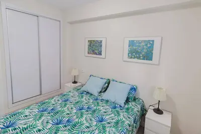a white room with a bed and two lamps at Victoria - Apartamento Playa in Cádiz