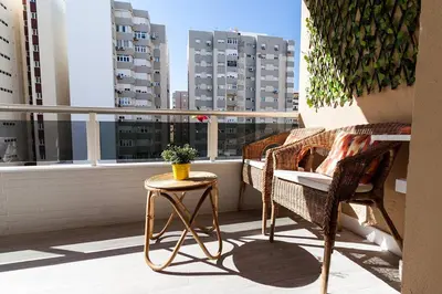 a balcony with a table and chairs and a window at Victoria - Apartamento Playa in Cádiz