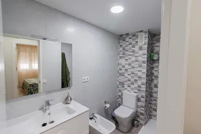 a bathroom with a sink and a toilet and a mirror at Victoria - Apartamento Playa in Cádiz