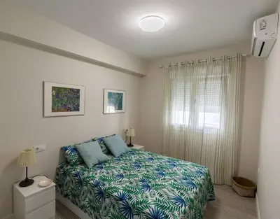 a small bedroom with a bed and a window at Victoria - Apartamento Playa in Cádiz
