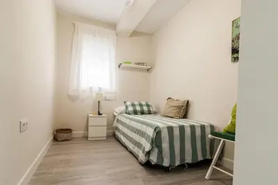 a small bedroom with a bed and a window at Victoria - Apartamento Playa in Cádiz