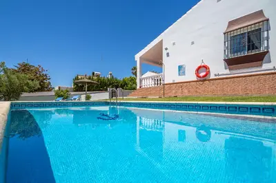 a large blue swimming pool in front of a building at Chalet Miriam II in Conil de la Frontera