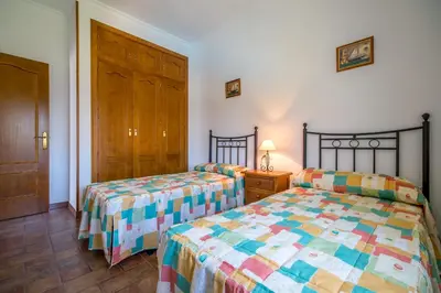 a bedroom with two beds and a wooden door at Chalet Miriam II in Conil de la Frontera