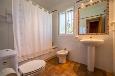a bathroom with a toilet and a sink and a mirror at Chalet Miriam II in Conil de la Frontera