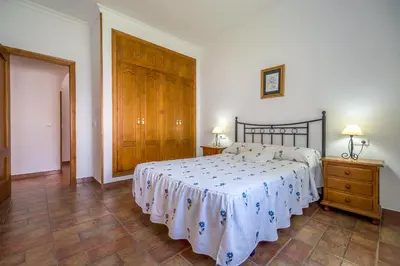 a bedroom with a bed and a wooden door at Chalet Miriam II in Conil de la Frontera