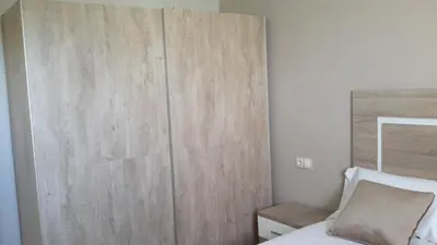 a bedroom with a wooden wall next to a bed at ATICO BAHÍA in Cádiz
