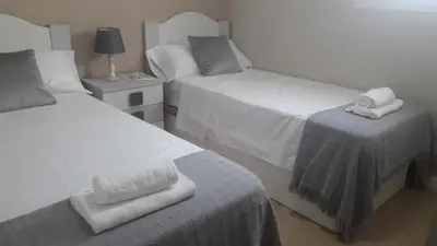 a bedroom with two beds with towels on top of it at ATICO BAHÍA in Cádiz