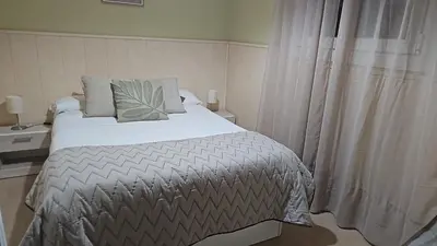 a bedroom with a large bed and a window at ATICO BAHÍA in Cádiz