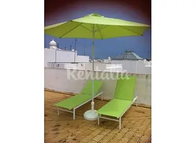 two green chairs and an umbrella on a roof at Apartamento Centro de Cádiz y Playa in Cádiz