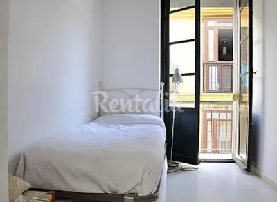 a bedroom with a bed and a door to a balcony at Apartamento Centro de Cádiz y Playa in Cádiz