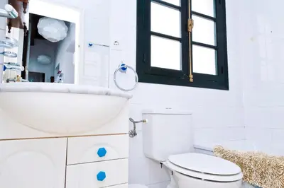 a bathroom with a sink and a toilet and a window at Apartamento Centro de Cádiz y Playa in Cádiz