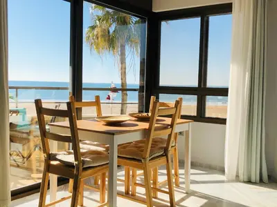 a dining room table and chairs with a view of the ocean at Victoria Beach Sunset Lounge in Cádiz