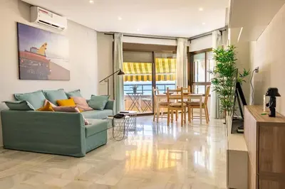 a living room with a green couch and a table at Victoria Beach Sunset Lounge in Cádiz