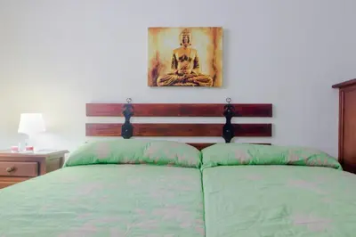 a bedroom with a bed with a picture on the wall at Calma holiday home in Conil de la Frontera