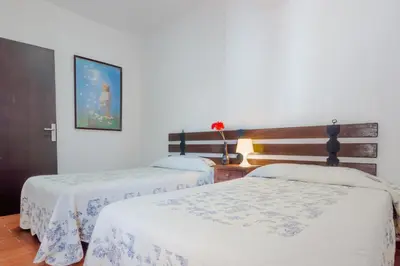 two beds in a room with white walls at Calma holiday home in Conil de la Frontera