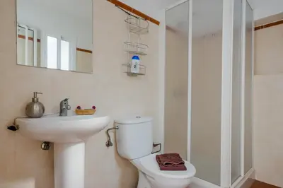 a bathroom with a toilet and a sink and a shower at Calma holiday home in Conil de la Frontera