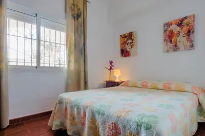 a bedroom with a bed and a window at Calma holiday home in Conil de la Frontera