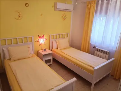 two beds in a small room with yellow walls at Villa de Limones in Chiclana de la Frontera