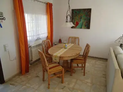 a dining room with a wooden table and chairs at Villa de Limones in Chiclana de la Frontera