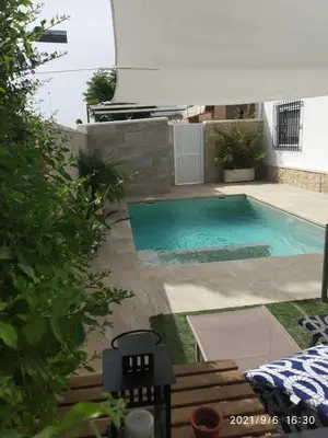 a swimming pool in the backyard of a house at La Orquídea Morada in Conil de la Frontera