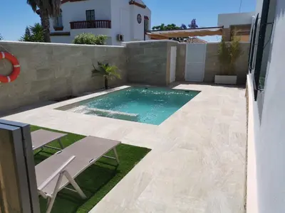 a swimming pool in the backyard of a house at La Orquídea Morada in Conil de la Frontera