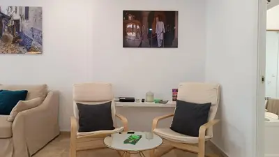 a living room with two chairs and a table at Sherryflat Torneria- Parking in Jerez de la Frontera
