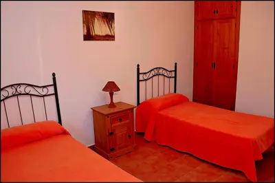 a bedroom with two beds and a dresser with a lamp at Apartamento con piscina comunitaria in Conil de la Frontera