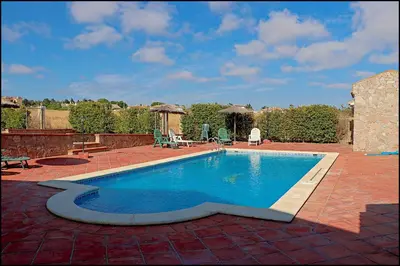 a swimming pool in a yard with a brick patio at Apartamento con piscina comunitaria in Conil de la Frontera