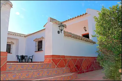 a white house with a red and white wall at Apartamento con piscina comunitaria in Conil de la Frontera