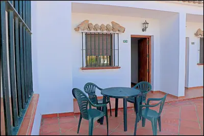 a table and chairs in a room with a window at Apartamento con piscina comunitaria in Conil de la Frontera