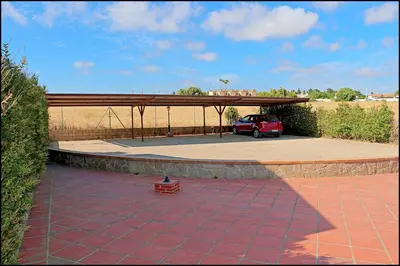 a parking lot with a car parked under a pavilion at Apartamento en complejo con piscina in Conil de la Frontera