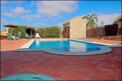 a swimming pool in a yard with a brick patio at Apartamento Cala de Puntalejo in Conil de la Frontera