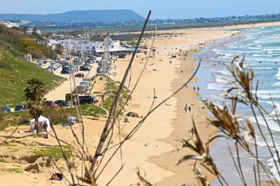 a beach with a lot of people on it at Apartamento Cala de Puntalejo in Conil de la Frontera
